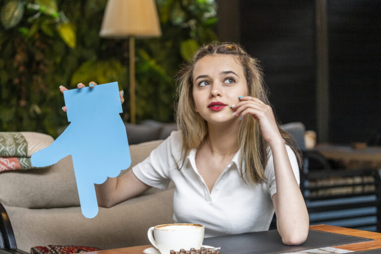 pomoc psychologa online - kobieta myśląca z niebieską dłónią papierowa